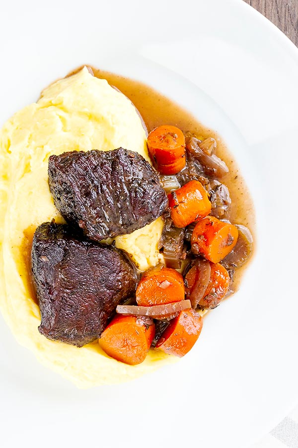 red wine braised venison roast overhead with potatoes and carrots