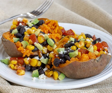 Our Southwest Stuffed Sweet Potatoes are filled with a homemade corn salsa, queso fresco, avocado, and black beans for a nutrient rich twist on a loaded baked potato. | www.CuriousCuisiniere.com
