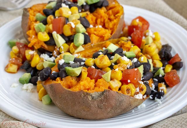 Our Southwest Stuffed Sweet Potatoes are filled with a homemade corn salsa, queso fresco, avocado, and black beans for a nutrient rich twist on a loaded baked potato. | www.CuriousCuisiniere.com