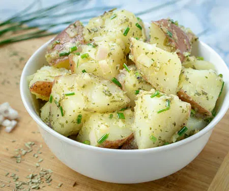 French Potato Salad is a welcoming blend of French herbs in a light red wine vinaigrette dressing. This potato salad recipe is perfect for a summer cookout!   | www.CuriousCuisiniere.com
