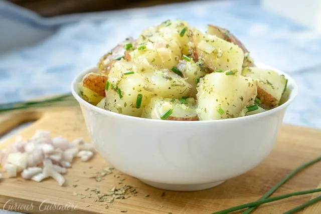 French Potato Salad is a welcoming blend of French herbs in a light red wine vinaigrette dressing. This potato salad recipe is perfect for a summer cookout!&nbsp;&nbsp; | www.CuriousCuisiniere.com 
