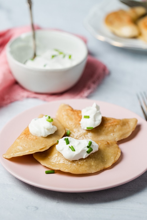 Polish pierogi filled with sauerkraut and topped with sour cream 