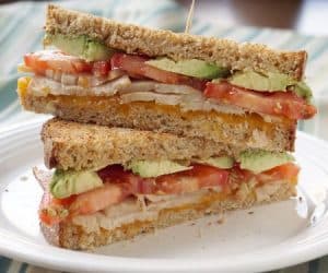 Smooth avocado pairs with juicy turkey, tomatoes, and the sharp cheddar cheese to make the perfect, warm and toasty Turkey Avocado Melt. | www.CuriousCuisiniere.com