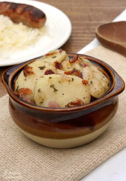 Tangy and slightly sweet, this Bavarian Potato Salad brings bacon and a warm vinegar dressing together for one tasty side dish! | www.CuriousCuisiniere.com