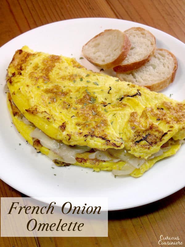 Fluffy eggs are filled with flavorful caramelized onions and sharp Swiss cheese in an omelette inspired by the flavors of French onion soup. | www.CuriousCuisiniere.com 