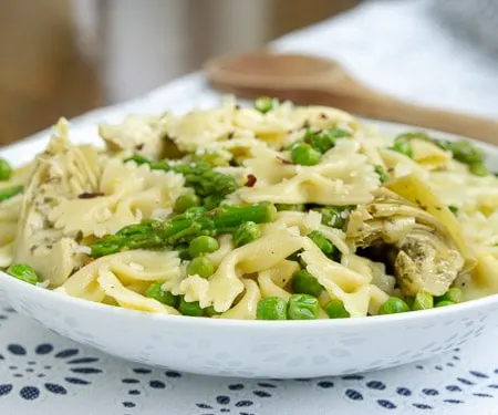 Peas, asparagus, and artichokes come together in an lemon vinaigrette, making this Lemon Asparagus Pasta salad the perfect side dish or light spring lunch. | www.CuriousCuisiniere.com