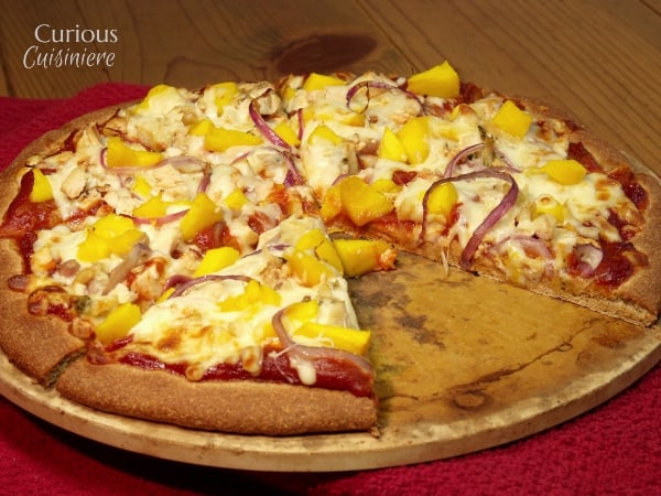 This Mango BBQ Chicken Pizza combines a sweet mango barbecue sauce with chicken and the unlikely sweet pizza topping of fresh mangoes for one delicious pizza that reminds us of a summer barbecue.   |  Curious Cuisiniere