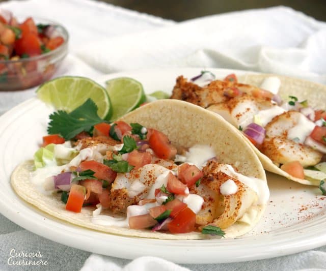 Fish Tacos are a classic Mexican dish that has made their way to Southern California. This version uses grilled fish and a lime salsa for a bright combo! | www.CuriousCuisiniere.com