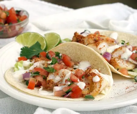 Fish Tacos are a classic Mexican dish that has made their way to Southern California. This version uses grilled fish and a lime salsa for a bright combo! | www.CuriousCuisiniere.com