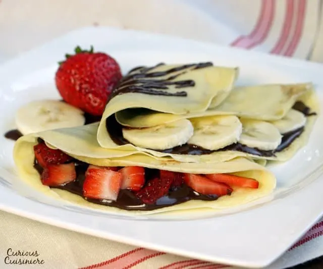 Sweet French Crepes are the perfect, elegant yet easy dessert recipe. Sometimes we have them as a treat for breakfast with strawberries and bananas. They are pancakes after all! | www.CuriousCuisiniere.com