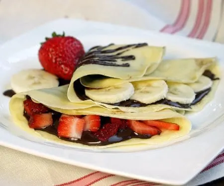 Sweet French Crepes are the perfect, elegant yet easy dessert recipe. Sometimes we have them as a treat for breakfast with strawberries and bananas. They are pancakes after all! | www.CuriousCuisiniere.com