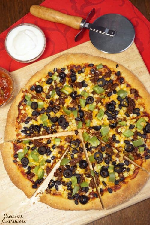 This Cornmeal Pizza Crust recipe is quick and easy to make. Load up your Mexican Pizza with your favorite Mexican inspired toppings for an easy weeknight meal! | www.CuriousCuisiniere.com