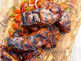 Country style rib marinade on pork ribs, stacked on a cutting board