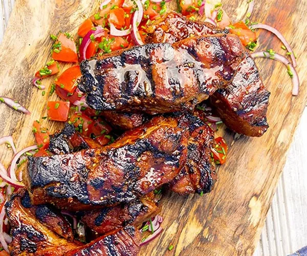 Country style rib marinade on pork ribs, stacked on a cutting board