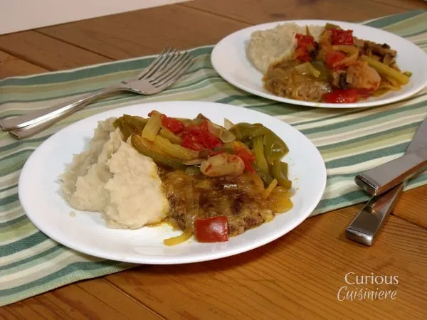 Tender steak is slow simmered in a veggie mixture for perfectly combined flavors that create a heavenly combo when this Swiss Steak is paired with mashed potatoes. | www.cuiouscuisiniere.com