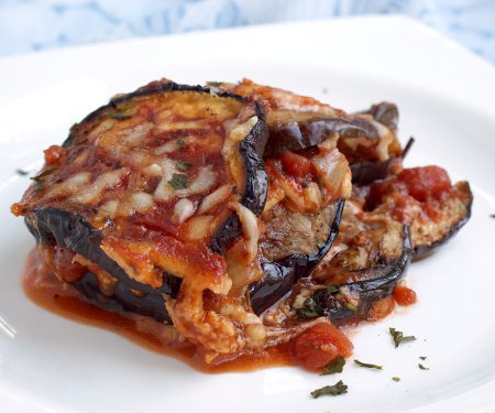 Parmigiana di Melanzane, or Eggplant Parmesan, is a simple but elegant Italian recipe. Our version of this vegetarian dish is lighter than many and includes a Fresh Herb Tomato Sauce that is perfect for summer! | www.CuriousCuisiniere.com