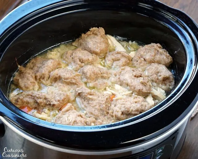 This Slow Cooker Chicken and Dumplings recipe is a hearty and slightly creamy stew made completely from scratch without canned cream of chicken soup!  | www.CuriousCuisiniere.com