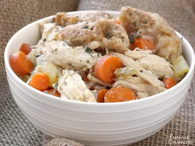 This Slow Cooker Chicken and Dumplings recipe is a hearty and slightly creamy stew made completely from scratch without canned cream of chicken soup!  | www.CuriousCuisiniere.com