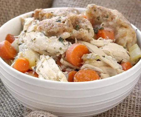 This Slow Cooker Chicken and Dumplings recipe is a hearty and slightly creamy stew made completely from scratch without canned cream of chicken soup!  | www.CuriousCuisiniere.com