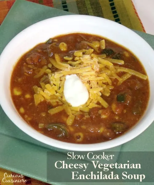 This slow cooker Cheesy Vegetarian Enchilada Soup is packed full of flavorful peppers and hearty beans for a quick weeknight meal. | www.curiouscuisiniere.com