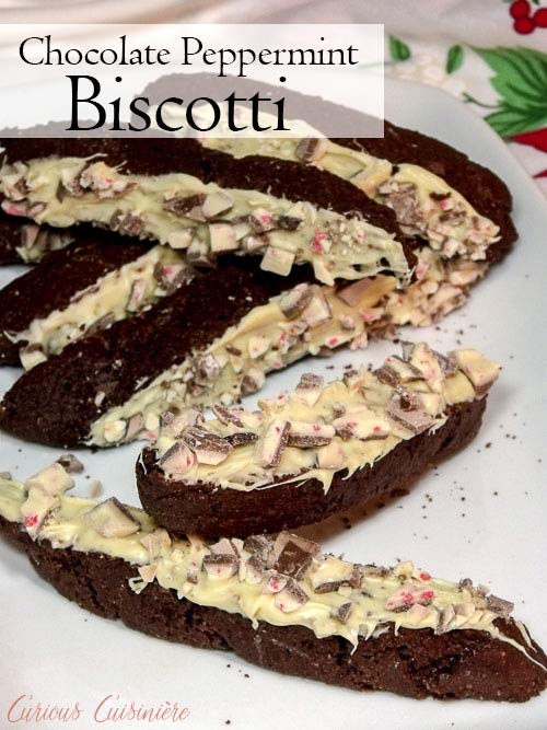 Chocolate peppermint biscotti is dipped in white chocolate and peppermint bark for a festive treat perfect with your morning coffee or cocoa. | www.CuriousCuisiniere.com