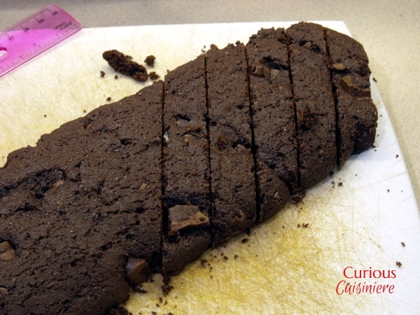 Chocolate peppermint biscotti is dipped in white chocolate and peppermint bark for a festive treat perfect with your morning coffee or cocoa. | Curious Cuisiniere