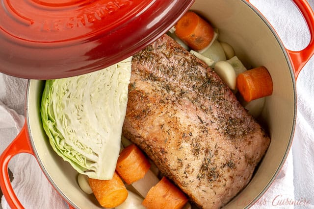 Corned beef brisket before cooking in a Dutch oven with cabbage, carrots, and poratoes