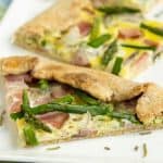 This Ham and Asparagus Tart is light and perfect for spring with strips of leftover ham and thin asparagus spears, roasted perfectly in a lemon herb crust. | www.CuriousCuisiniere.com