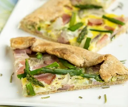 This Ham and Asparagus Tart is light and perfect for spring with strips of leftover ham and thin asparagus spears, roasted perfectly in a lemon herb crust. | www.CuriousCuisiniere.com