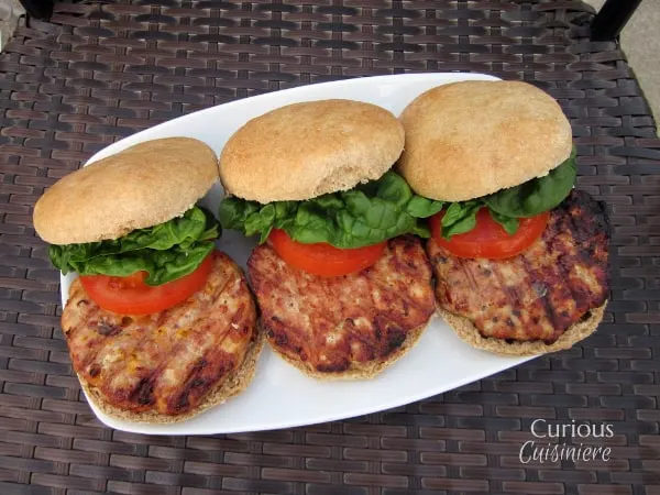 These homemade hamburger buns go from a pile of ingredients to fluffy, golden buns in less than an hour. | www.CuriousCuisiniere.com