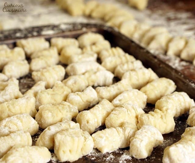 For the spring, we love to serve our homemade gnocchi with pesto and peas. It's the perfect light and flavorful spring dinner recipe! | www.CuriousCuisiniere.com