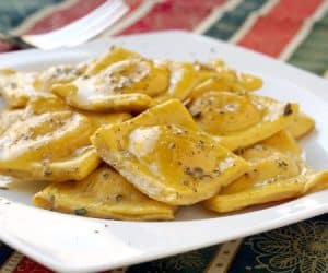 Pumpkin infused homemade pasta makes the perfect vessel for a creamy tarragon cheese filling in this fall Pumpkin Ravioli Recipe.  | www.CuriousCuisiniere.com