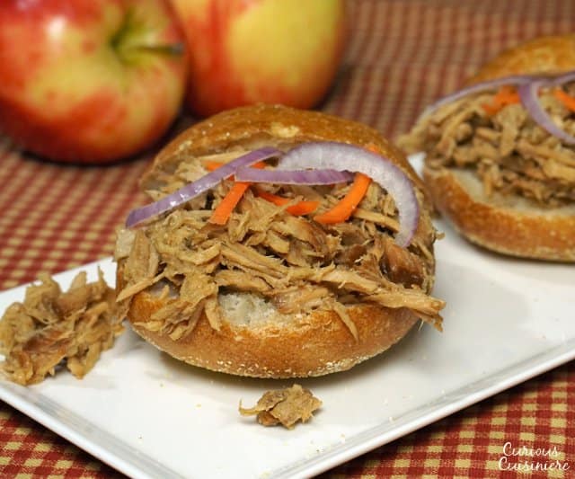 Apple adds sweetness to this slow cooker bourbon pulled pork. This dish makes for great appetizer sliders or an easy main meal! Double (or triple) the recipe to serve a crowd! | www.CuriousCuisiniere.com 