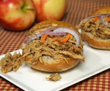 Apple adds sweetness to this slow cooker bourbon pulled pork. This dish makes for great appetizer sliders or an easy main meal! Double (or triple) the recipe to serve a crowd! | www.CuriousCuisiniere.com