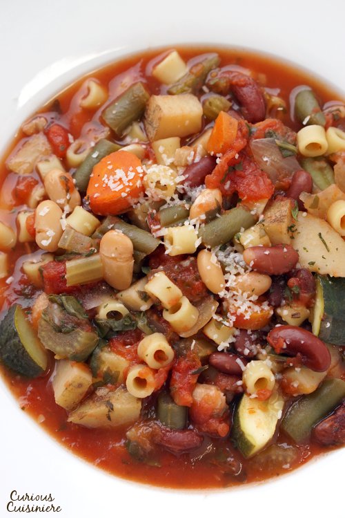 Our crock pot Minestrone is not a wimpy soup. Full of chunky vegetables and laden with herbs, this is some serious comfort food made easy in your slow cooker. | www.CuriousCuisiniere.com