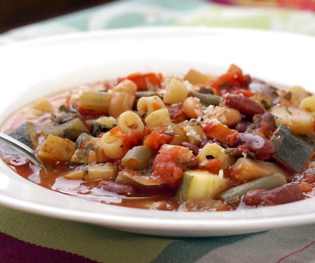 Our crock pot Minestrone is not a wimpy soup. Full of chunky vegetables and laden with herbs, this is some serious comfort food made easy in your slow cooker. | www.CuriousCuisiniere.com
