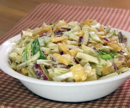 Smooth, sharp cheddar meets sweet, crisp apples in this flavor-explosion Cheddar Apple Slaw that is sure to be the star of your next cookout or game day party. | www.CuriousCuisiniere.com