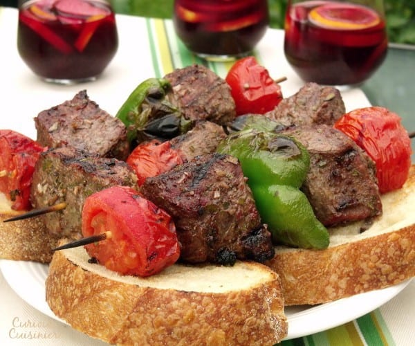 Tender, juicy grilled beef seasoned with garlic and bay, served over thick slices of crusty bread. Big, juicy grill-seared chunks of beef served over thick slices of artisan bread. Espetada, or Portuguese Beef Skewers, is the perfect summer party recipe. | www.CuriousCuisiniere.com 