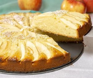 A slice of moist and buttery Apfelkuchen, German Apple Cake, being removed. | www.CuriousCuisiniere.com