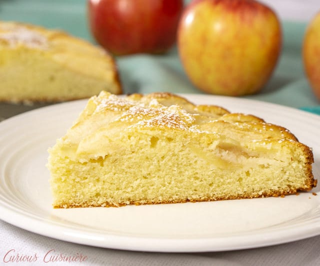 A slice of moist and buttery Apfelkuchen, German Apple Cake, served on a plate. | www.CuriousCuisiniere.com