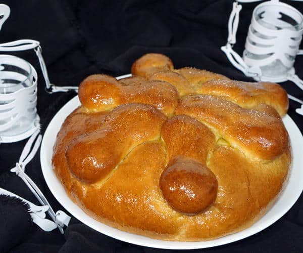 Pan de Muerto is a light and sweet Mexican Day of the Dead bread, traditionally spiced with ground anise and brushed with an orange glaze.