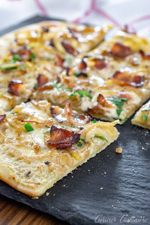 Bacon, caramelized onions, and a creamy base make up this classic German pizza, Flammkuchen, all on top of a cracker-thin, crispy crust. 