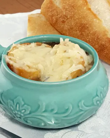 Comforting French Onion Soup combines caramelized onions, crisp toast, and gooey cheese for one comforting dish. | www.curiouscuisiniere.com