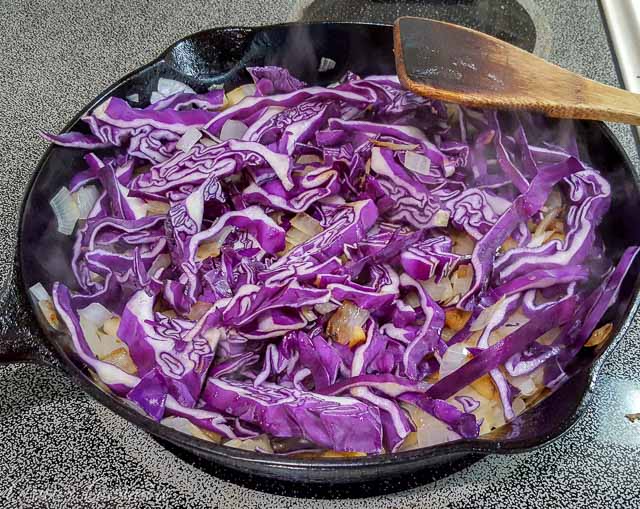 Making Blaukraut German braised red cabbage in a cast iron skillet. 