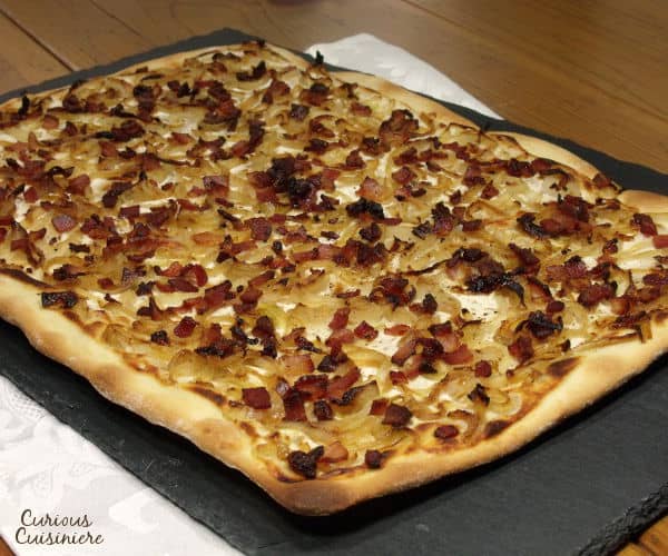 Bacon, caramelized onions, and a creamy base make up this classic German pizza, all on top of a cracker-thin, crispy crust. | www.curiouscuisiniere.com