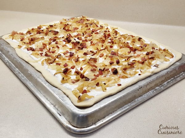 Bacon, caramelized onions, and a creamy base make up Flammkuchen, this classic German pizza, all on top of a cracker-thin, crispy crust. | www.curiouscuisiniere.com