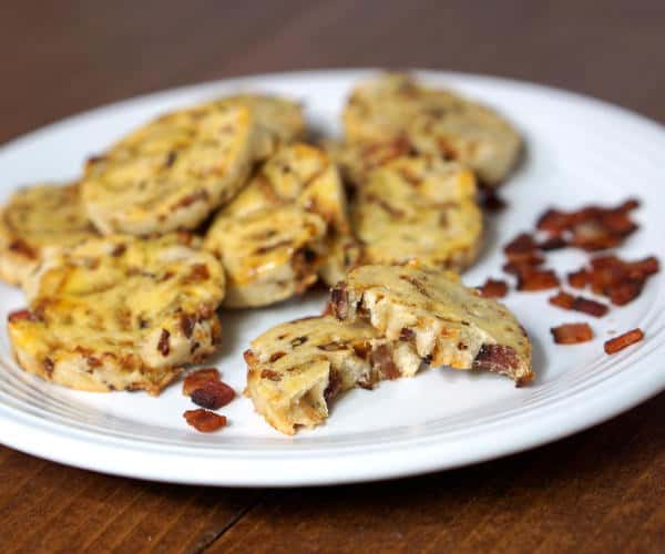 Smoky bacon and caramelized onions bring these savory German Bacon Cookies to life. This recipe is a perfect appetizer or small bite for a cocktail party. | www.curiouscuisiniere.com