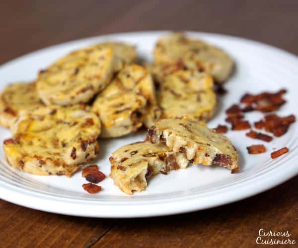 Smoky bacon and caramelized onions bring these savory German Bacon Cookies to life. This recipe is a perfect appetizer or small bite for a cocktail party. | www.curiouscuisiniere.com