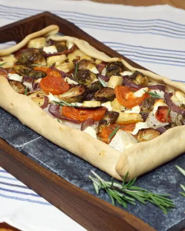 This rustic, free-form Tarte Provencale is filled with flavorful roasted winter vegetables and creamy goat cheese. It is the perfect recipe for a comforting winter appetizer. | www.CuriousCuisiniere.com