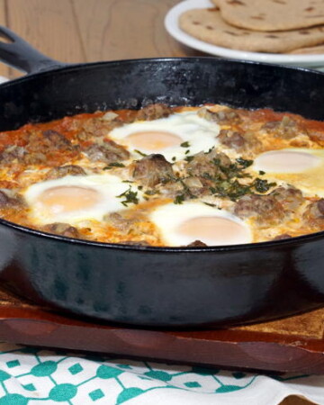 Kefta Mkaouara is a Moroccan dish made up of tiny meatballs, simmered in a flavorful tomato sauce and crowned with poached eggs. | www.CuriousCuisiniere.com